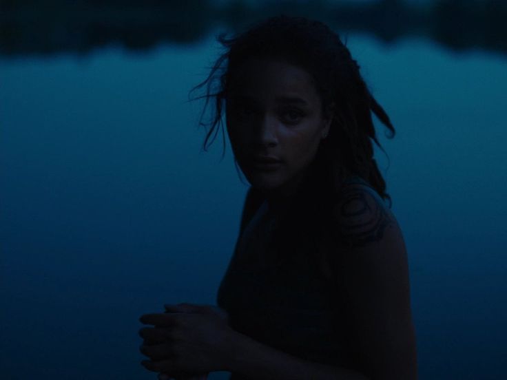 Lake at dusk – Star stands by a dark blue lake, her hair damp, shadows casting across her face in low evening light.